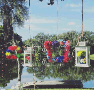 Colorful DIY floral wreaths made with painted hydrangeas spider mums and football mums hanging as party backdrop decorations