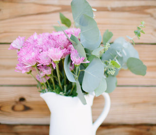Simple and beautiful DIY floral arrangement with lavender football mums eucalyptus and pittosporum in a vase as easy home decor