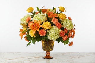 Leo zodiac flowers - yellow roses, orange lilies, yellow hydrangeas and orange carnations bouquet in a vase - farm-fresh flowers by Bloomingmore