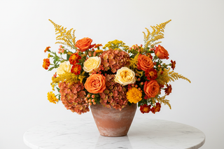 Sagittarius zodiac flowers - orange roses, yellow roses, orange hydrangeas, yarrow and marigold bouquet in a vase - farm-fresh flowers by Bloomingmore